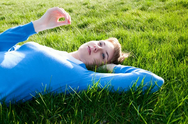 Vacker flicka liggande på gräset — Stockfoto