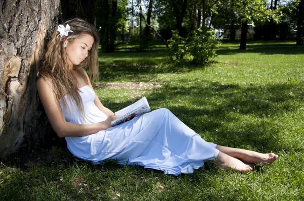 Giovane donna che legge libro nel parco — Foto Stock