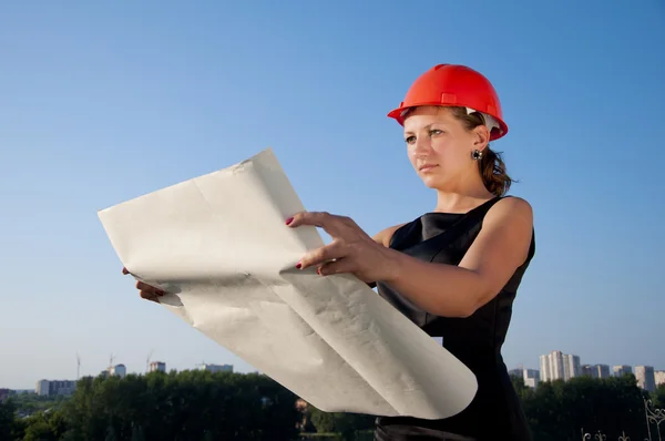 Business woman considers construction plans — Stok fotoğraf