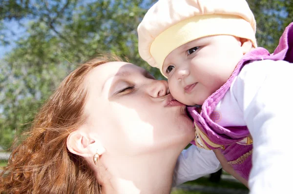 Schöne Mutter küsst das Kind — Stockfoto