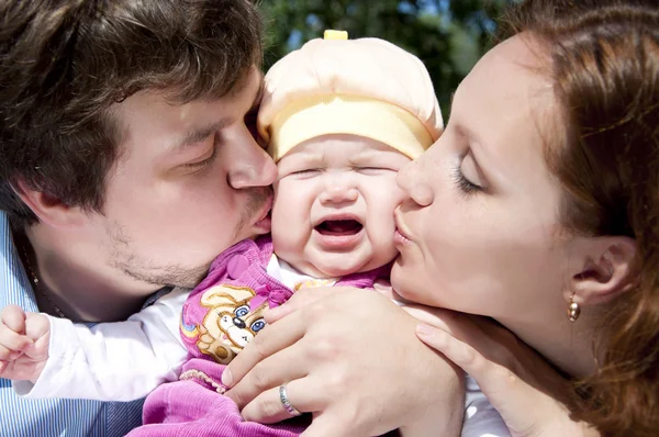 Parents kissing baby — Stock Photo, Image
