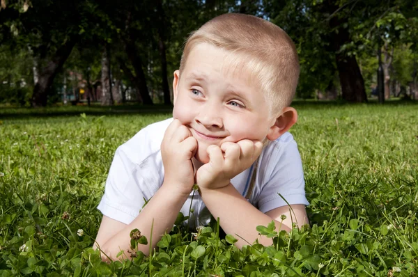 Lindo chico acostado en la hierba — Foto de Stock