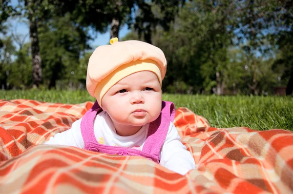 Portrait of the baby, on coverlet in the park — Stock Photo, Image