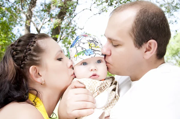 Родители целуют своего малыша — стоковое фото