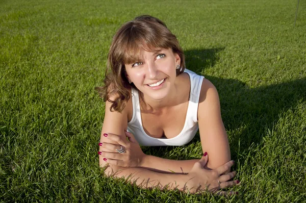 Mooie jonge vrouw die lacht op grasveld — Stockfoto