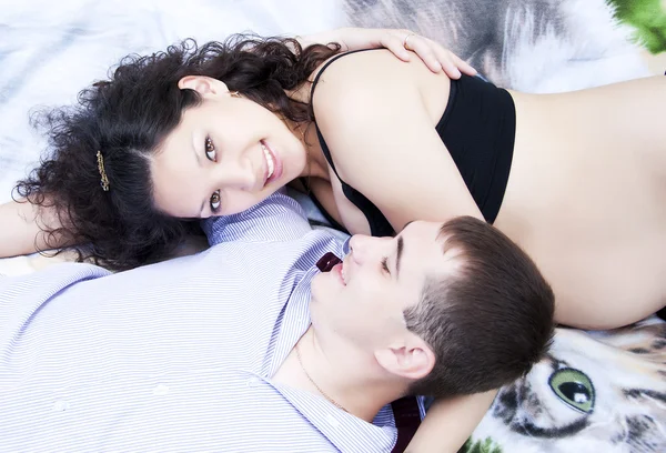 Пара ложится вместе, обнимается, беременная женщина — стоковое фото