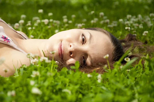 Mooie jonge vrouw die lacht op grasveld — Stockfoto