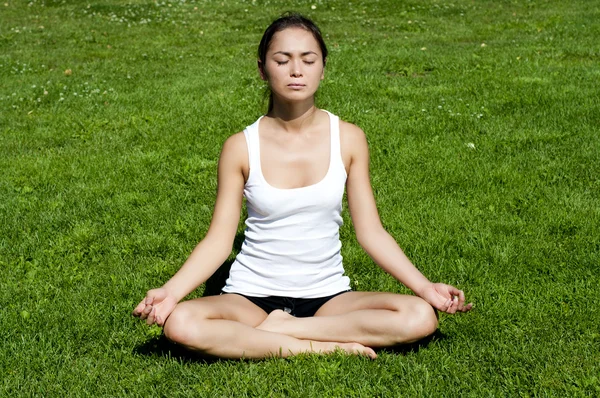 Mulher de ioga na grama verde — Fotografia de Stock