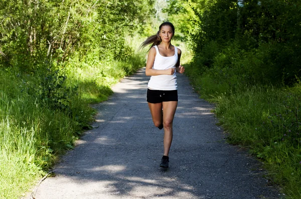 Junge Frau joggt im Sommer im Park — Stockfoto