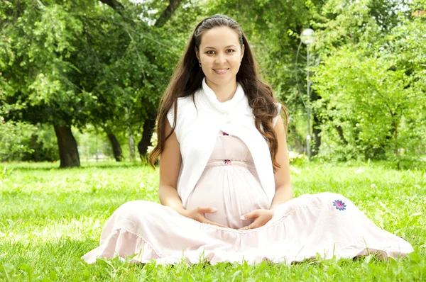 Bella donna incinta rilassante nel parco — Foto Stock