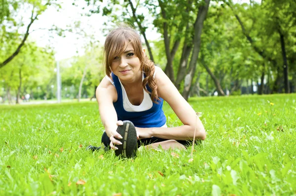 Yeşil çimlerde yoga yapan kadın. — Stok fotoğraf