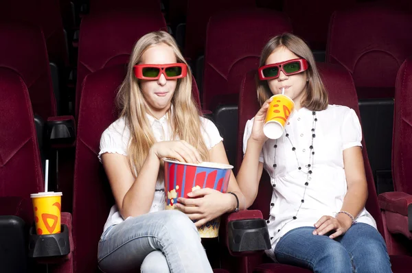 Zwei schöne Mädchen, die einen Film im Kino ansehen — Stockfoto