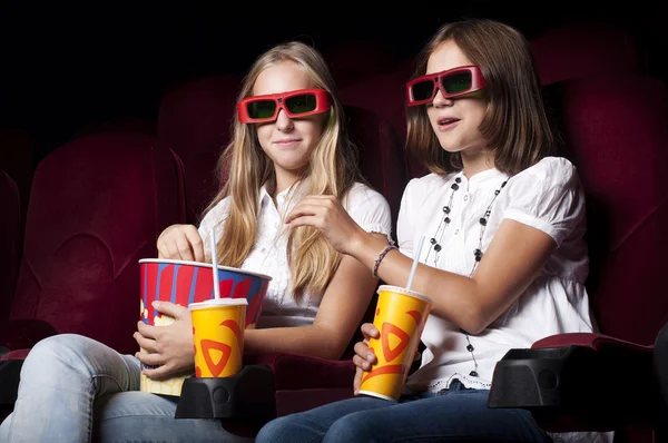 Dos hermosas chicas viendo una película en el cine — Foto de Stock
