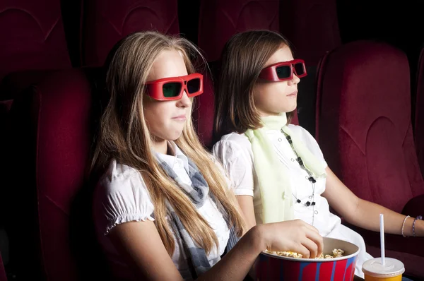 Två vackra flickor tittar på en film på bio Stockbild