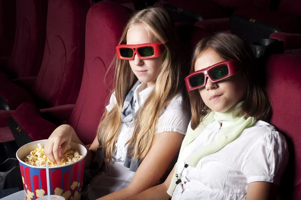 Две красивые девушки смотрят кино в кинотеатре Стоковое Изображение