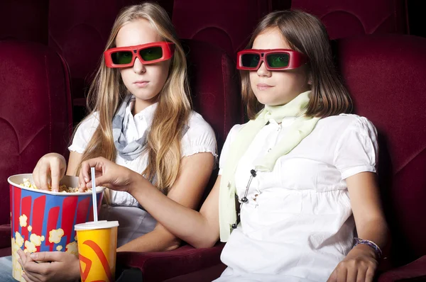 Две красивые девушки смотрят кино в кинотеатре Лицензионные Стоковые Изображения