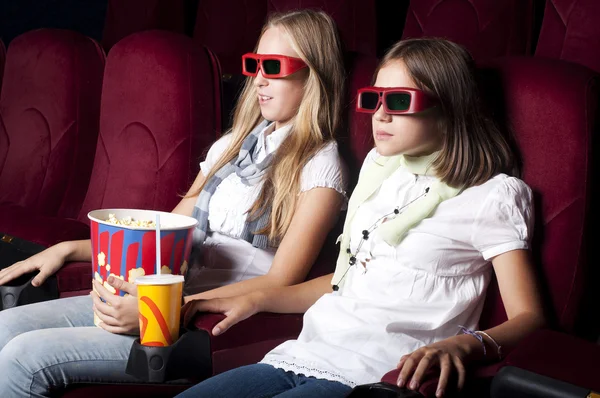 Dos hermosas chicas viendo una película en el cine — Foto de Stock