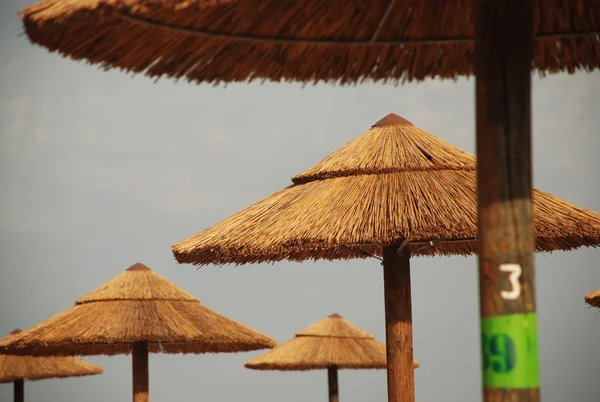 Ombrelloni di paglia sulla spiaggia — Foto Stock
