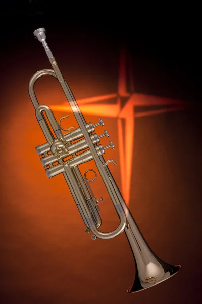 Золотая труба с крестом на оранжевом — стоковое фото