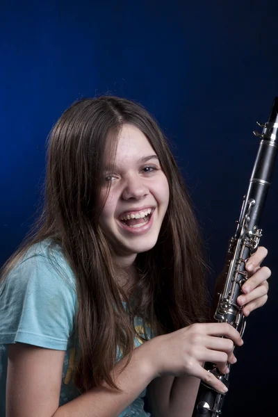 Genç kız klarnet çalar mavi — Stok fotoğraf