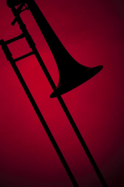 Тромбон силует ізольовано на червоному — стокове фото