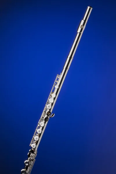 Srebrny flet na niebieskim tle — Zdjęcie stockowe