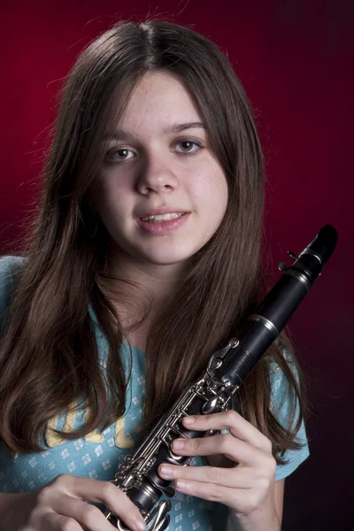 Tienermeisje klarinettist op rood — Stockfoto
