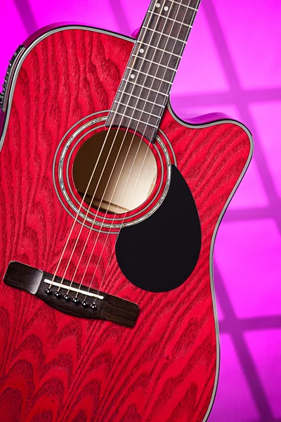Акустическая электрическая красная гитара в розовом цвете — стоковое фото