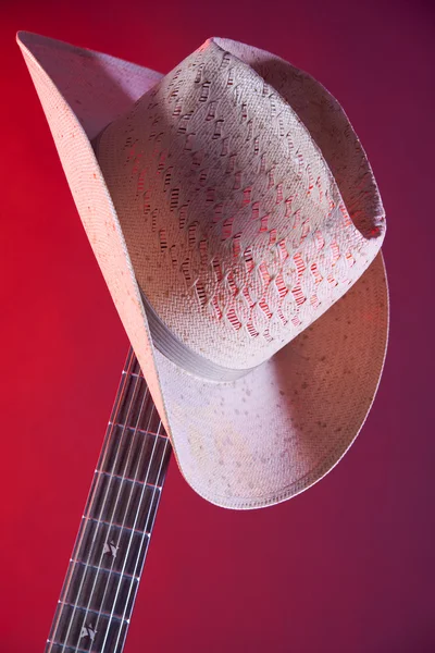 Guitar and Hat Isolated Against Red — Stock Photo, Image