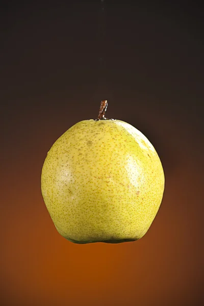 Maturo succosa pera frutta su sfondo oro — Foto Stock