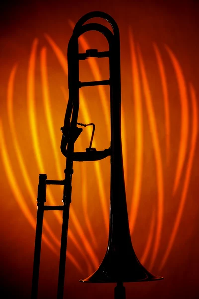 Trombon siluet turuncu üzerinde yapılan — Stok fotoğraf