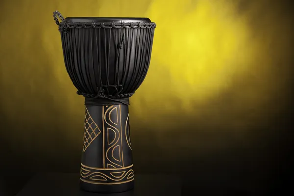 Black Djembe Drum Isolated on Yellow Spotlight — Stock Photo, Image