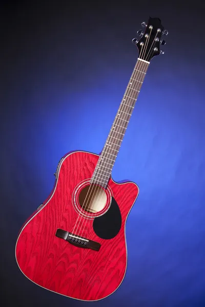 Guitarra roja aislada en azul —  Fotos de Stock