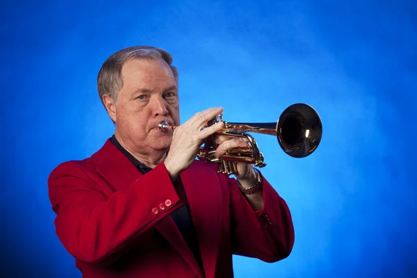 Senior man trompet spelen op blauw — Stockfoto