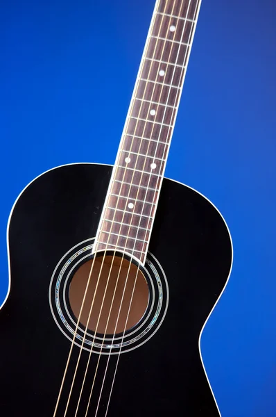 Preto guitarra acústica em azul — Fotografia de Stock