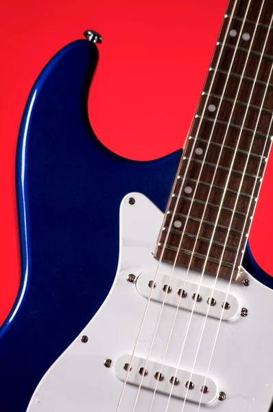 Gitarre blau elektrisch isoliert auf rot — Stockfoto