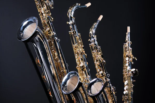Набор из четырех саксофонов на черном — стоковое фото