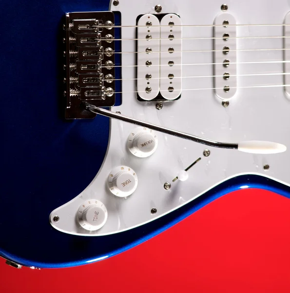 孤立在红色上的蓝色吉他 — 图库照片