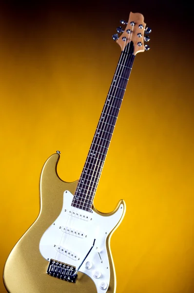 Золотая электрическая гитара на желтом — стоковое фото