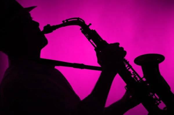 Saxofoon speelde in silhouet roze Rechtenvrije Stockfoto's