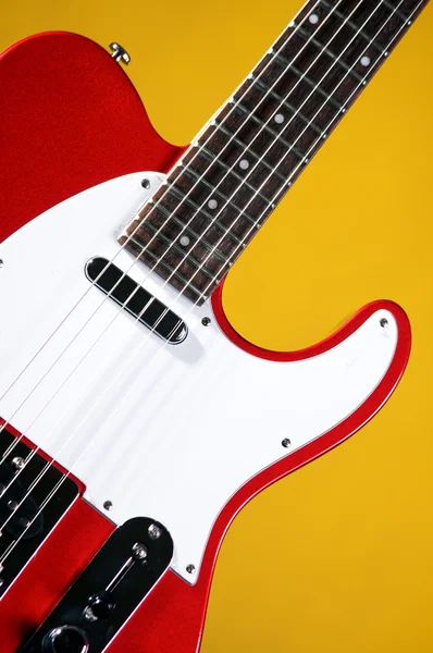 Metallic röd gitarr isolerad på gul — Stockfoto