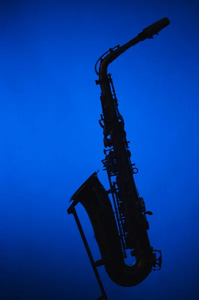 Saxofone silhueta contra holofotes azuis — Fotografia de Stock