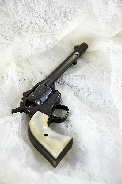 Pistola de revólver en un encaje — Foto de Stock