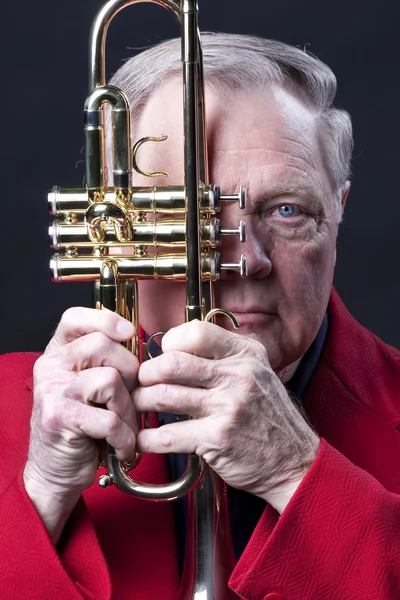 Senior male musiker anläggning trumpet på svart — Stockfoto