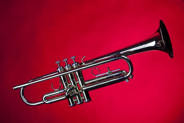 Guld trumpet isolerad på röd — Stockfoto