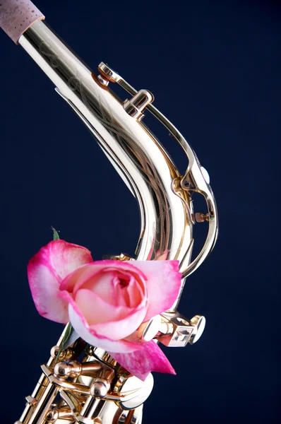Розовая роза на шее саксофона — стоковое фото