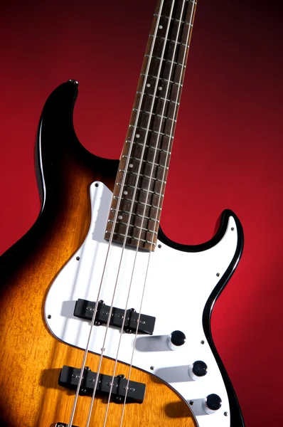 Sunburst Bass Guitar Isolated on Red — Stock Photo, Image
