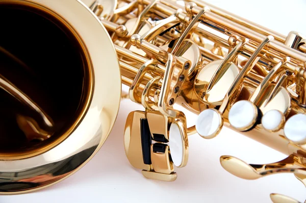 Guld saxofon på nära håll på vit — Stockfoto
