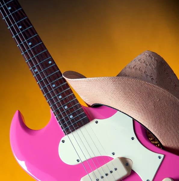 Guitarra rosa y sombrero occidental —  Fotos de Stock