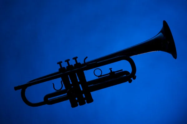 Silhueta de trompete isolada no azul — Fotografia de Stock